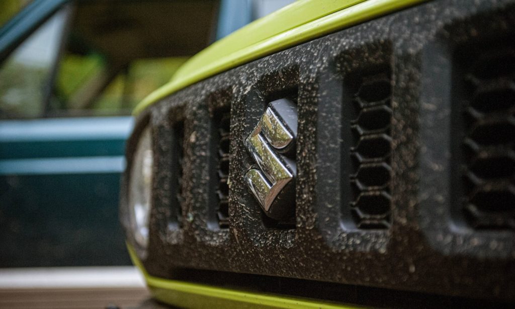 Suzuki Jimny : calandre et logo dans la forêt 