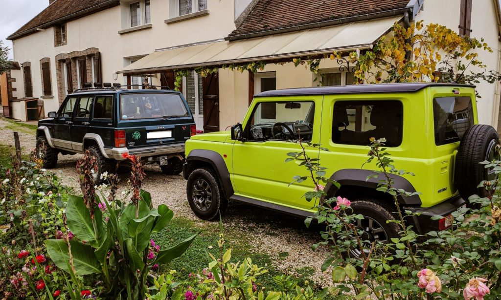 Suziuki Jimny et Jeep Cherokee dans une cours de maison de campagne 