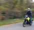 Motard roulant debout sur la Suzuki V-Strom 800 DE en coloris jaune.