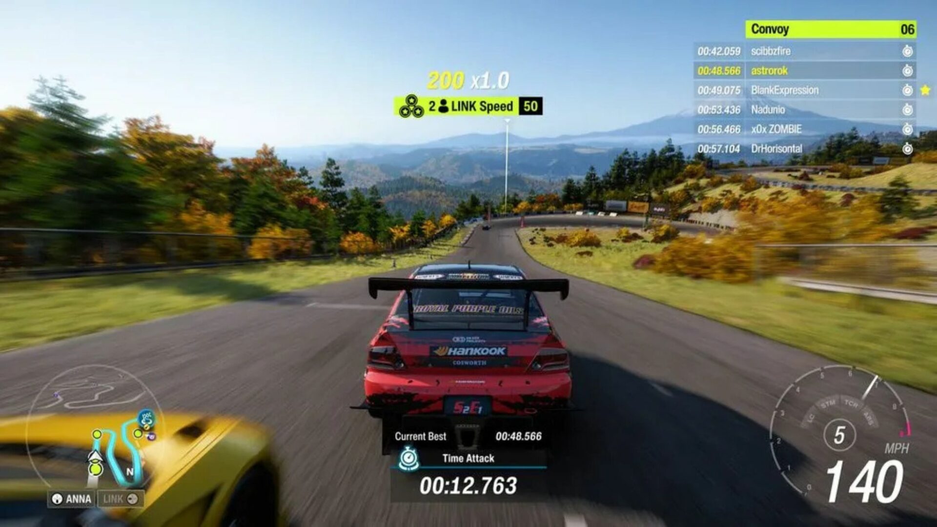 Vue à la troisième personne (gameplay) d'une Mitsubishi Lancer Evolution de Time Attack rouge et noire avec un immense aileron, négociant une épingle sur une route de montagne japonaise. L'interface affiche un chrono de 00:12.763, un compteur à 140 mph et des points de "LINK Speed". Le Mont Fuji est visible au loin sous un ciel dégagé.