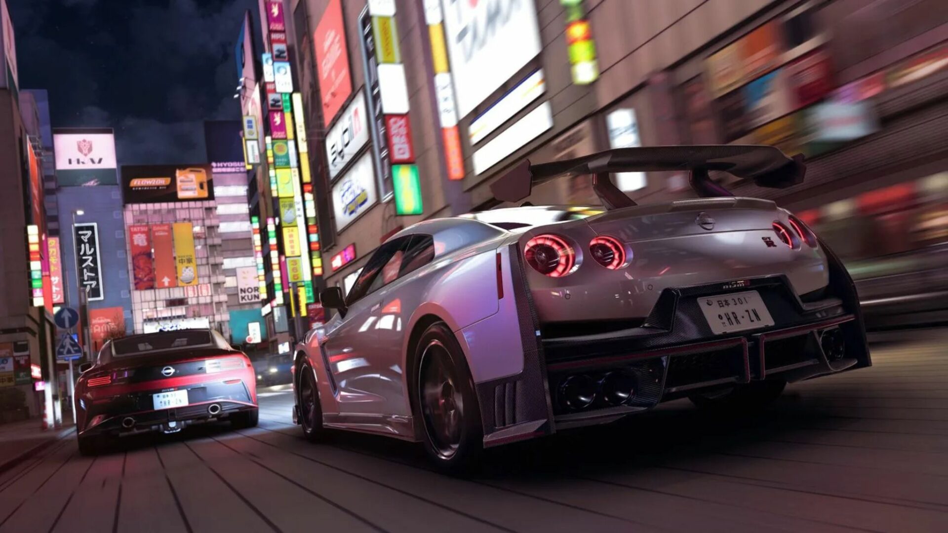 Une Nissan GT-R Nismo 2024 argentée avec un grand aileron arrière en fibre de carbone et des feux arrière LED distinctifs, vue de derrière, dérapant légèrement dans une rue de Tokyo bondée de néons et de panneaux d'affichage éclairés la nuit dans Forza Horizon 6.