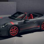 Porsche 911 GT3 cabriolet (S/C) grise avec jantes rouges magnésium et intérieur bicolore rouge/gris, vue de l'avant en studio.