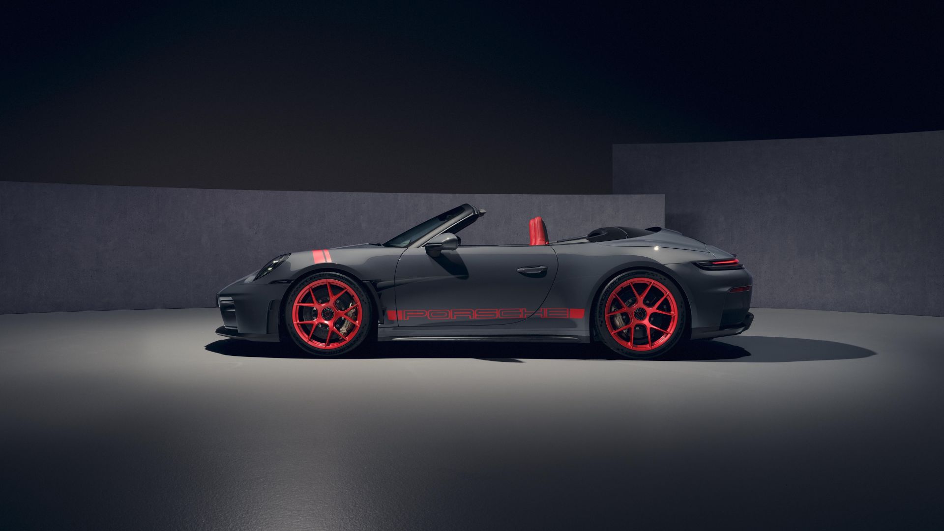Profil complet de la Porsche 911 GT3 cabriolet en Gris ardoise avec jantes magnésium rouges et capote ouverte.
