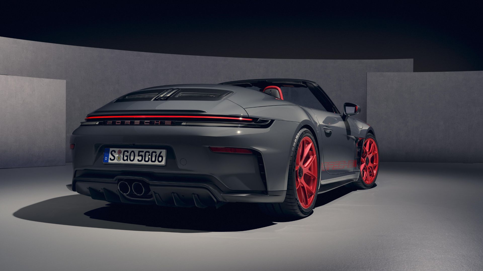 Vue arrière d'une Porsche 911 GT3 cabriolet grise avec échappement central double et jantes en magnésium rouge.