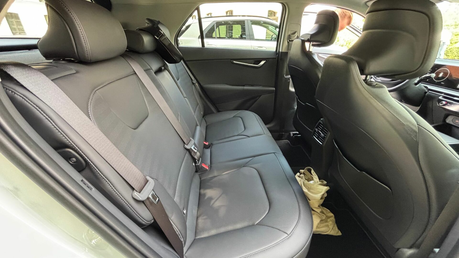 Banquette arrière en cuir synthétique sombre du Kia Niro Hybride 2026 montrant l'espace aux jambes généreux