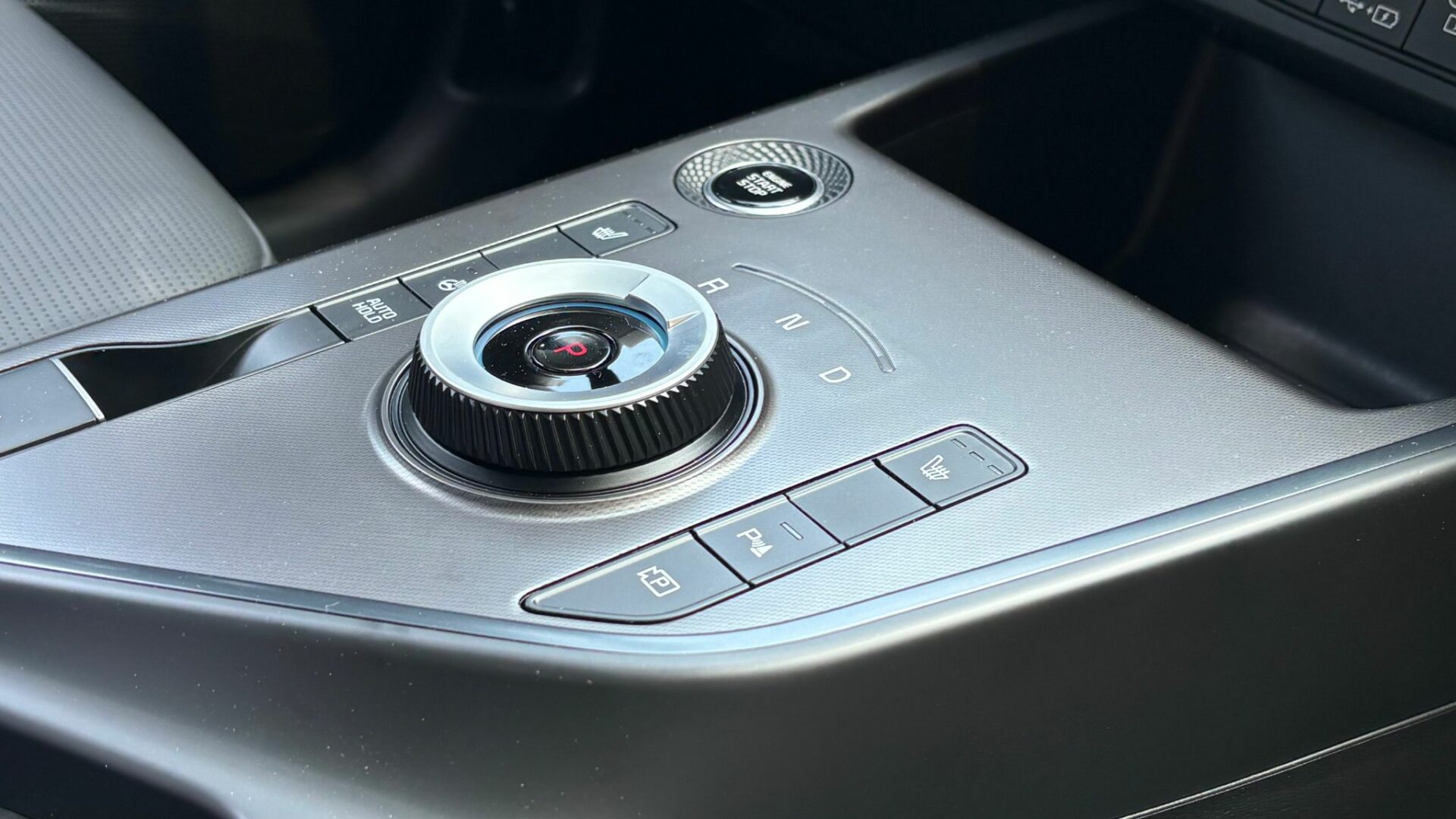 Gros plan sur la molette rotative du sélecteur de vitesse et les commandes physiques de la console centrale du Kia Niro Hybride 2026