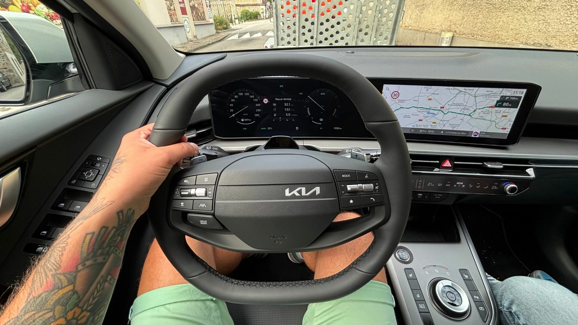Poste de conduite du Kia Niro Hybride 2026 en roulant avec volant deux branches, palettes de régénération et double écran