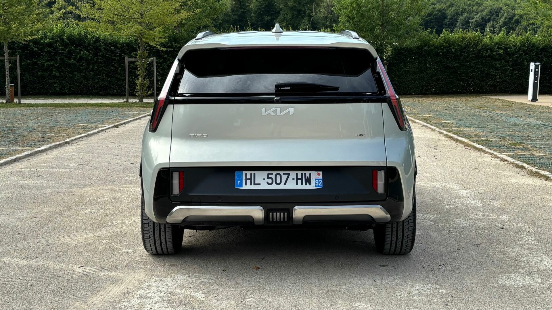 Vue plein arrière du Kia Niro Hybride 2026 Gris Ivoire avec ses feux boomerang verticaux et son monogramme HEV