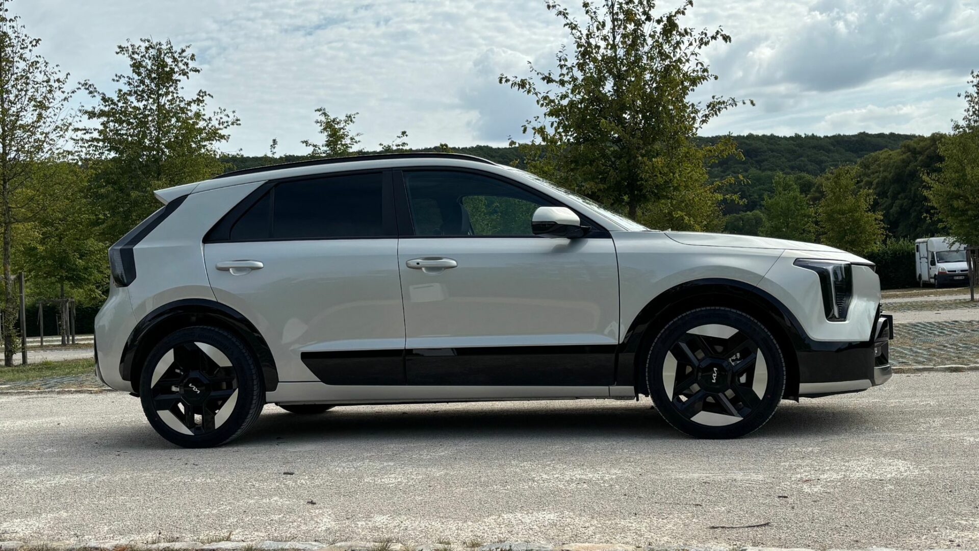Vue de profil du Kia Niro Hybride 2026 Gris Ivoire montrant son gabarit compact de 4,43 m et ses jantes bicolores