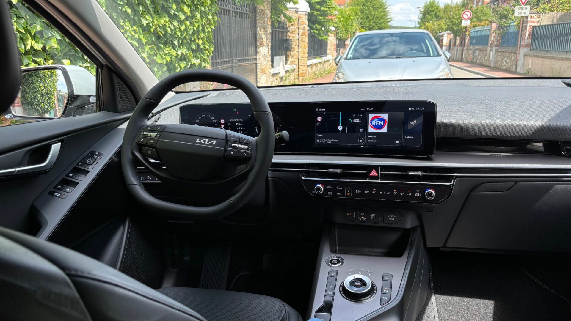 Vue sur le poste de conduite du Kia Niro Hybride 2026 mettant en valeur le volant multifonction et le double écran numérique