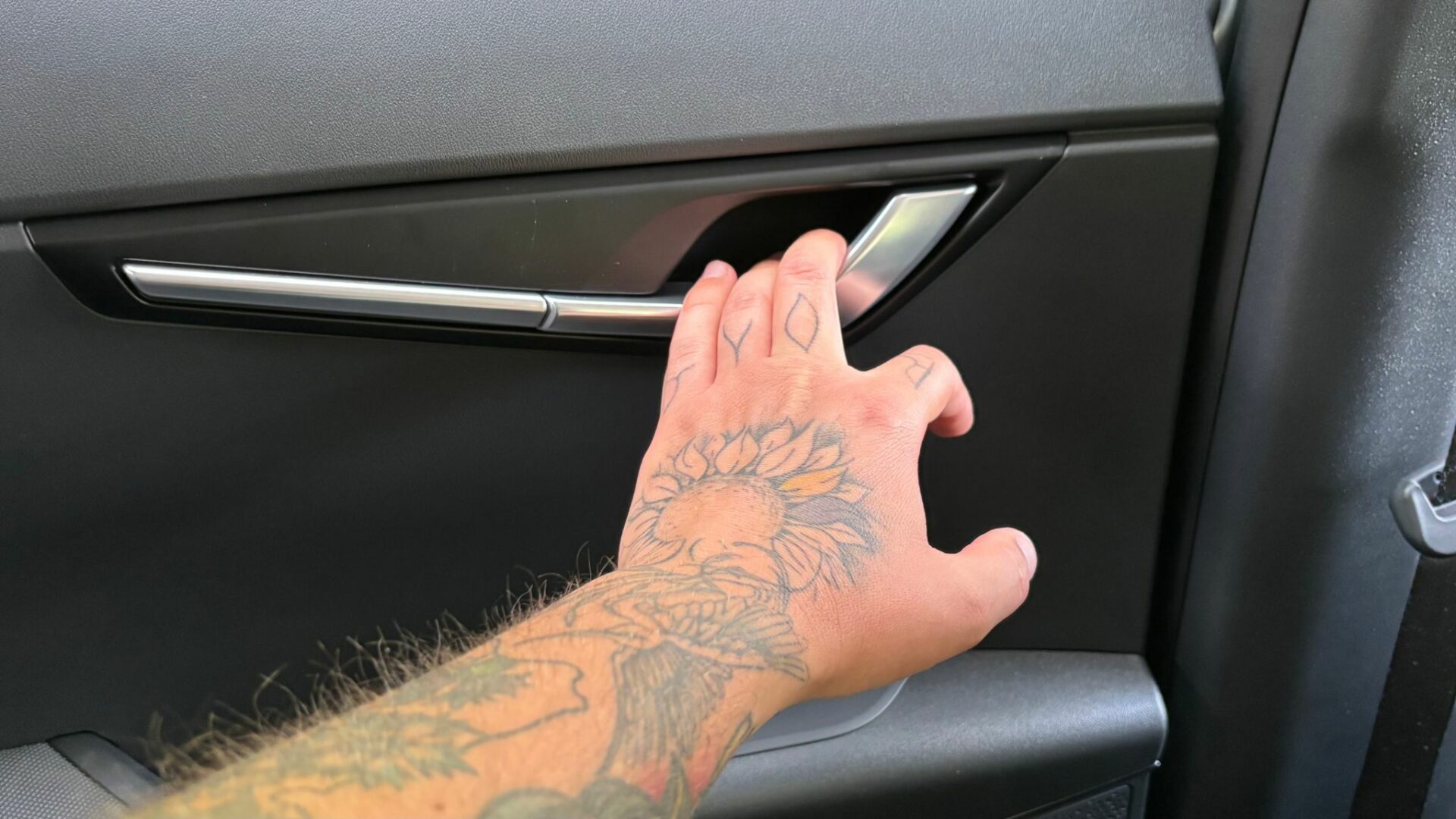 Gros plan sur la poignée de porte intérieure en aluminium satiné actionnée à la main dans le Kia Niro Hybride 2026
