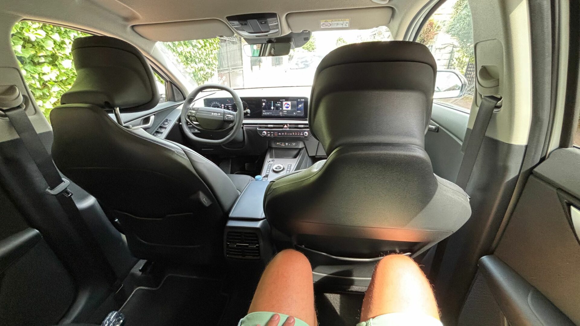 Vue POV depuis la banquette arrière montrant l'espace aux genoux généreux et les dossiers affinés des sièges du Kia Niro Hybride 2026