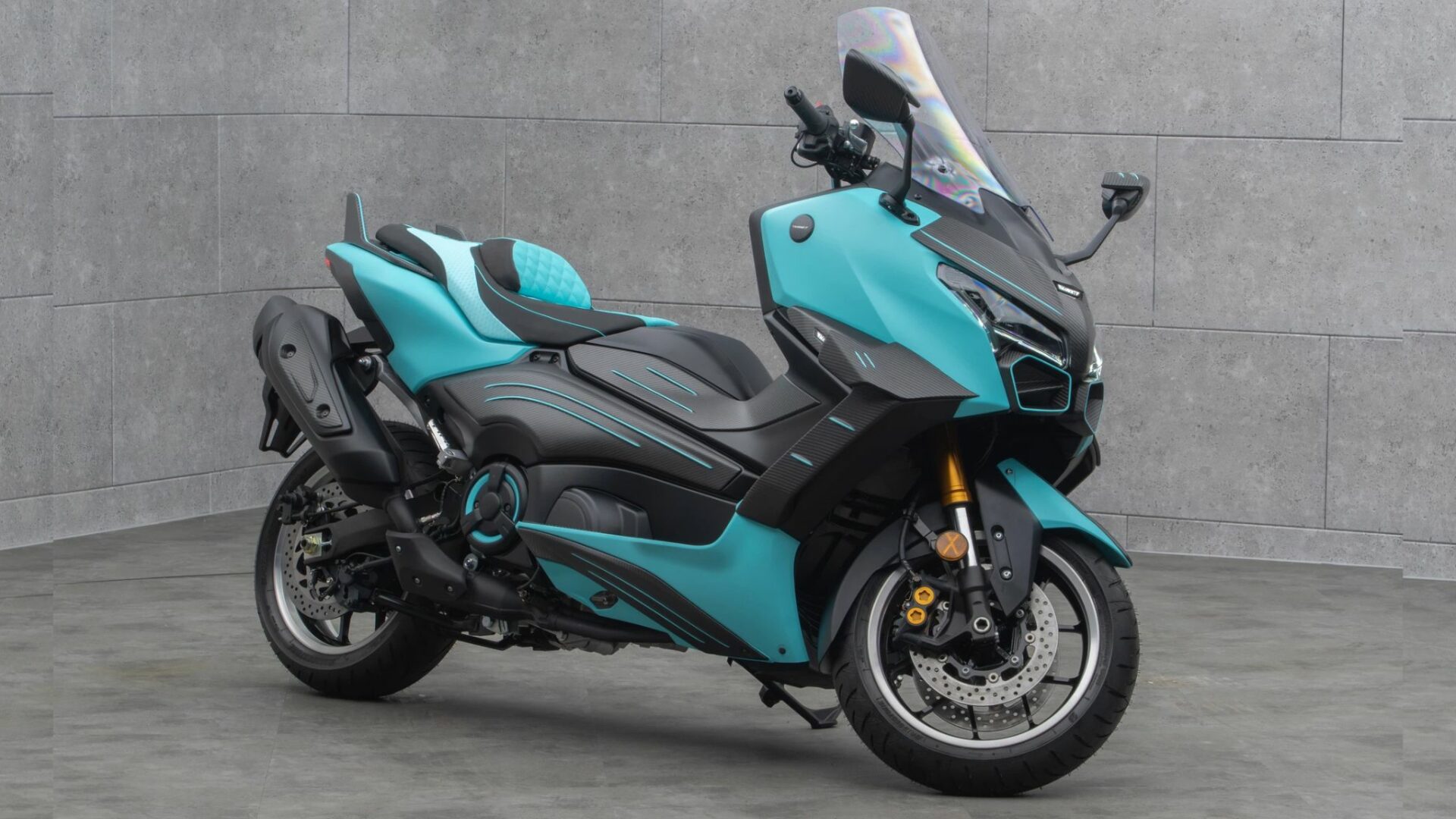 Vue trois-quarts avant côté droit du Mansory T-Max sur base de Yamaha TMAX 560 montrant le pot d'échappement et la carrosserie bleu clair
