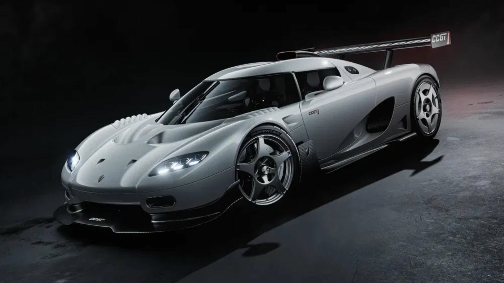 Vue de trois-quarts avant de la Koenigsegg CCGT1 en studio, affichant son splitter en carbone, ses optiques LED allumées et ses jantes à cinq branches