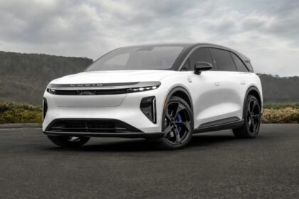 Vue de trois-quarts avant du Lucid Gravity GT-S blanc montrant son bouclier agressif, ses feux LED affinés et son badge d'ours bleu sur l'aile