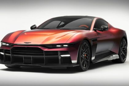 Vue de trois-quarts avant de l'Aston Martin Valen couleur rouge et bronze métallisé avec ses phares LED effilés et sa lame avant en carbone