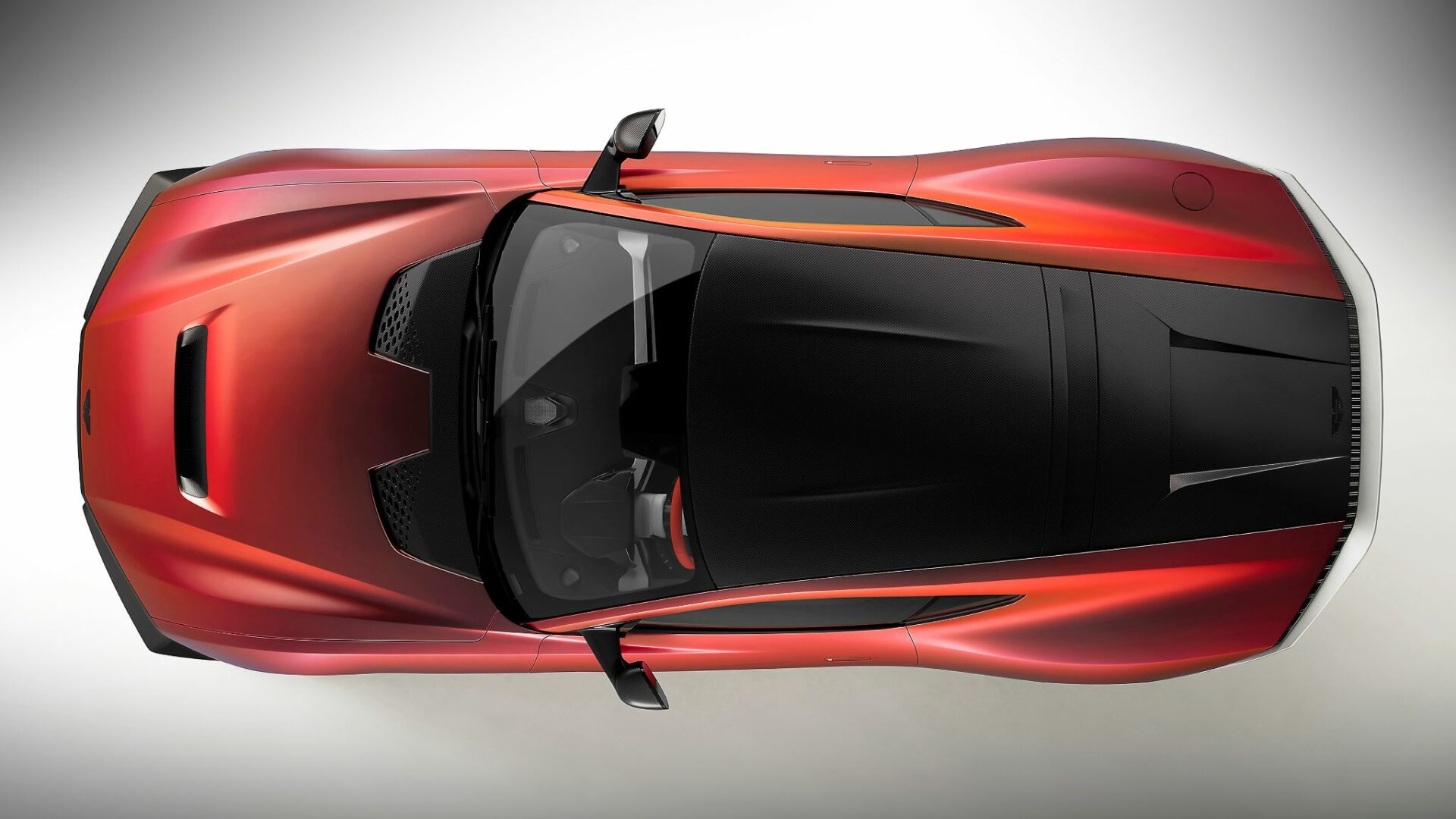 Vue aérienne plongeante de l'Aston Martin Valen montrant son capot ventilé, son toit en fibre de carbone et l'absence totale de lunette arrière