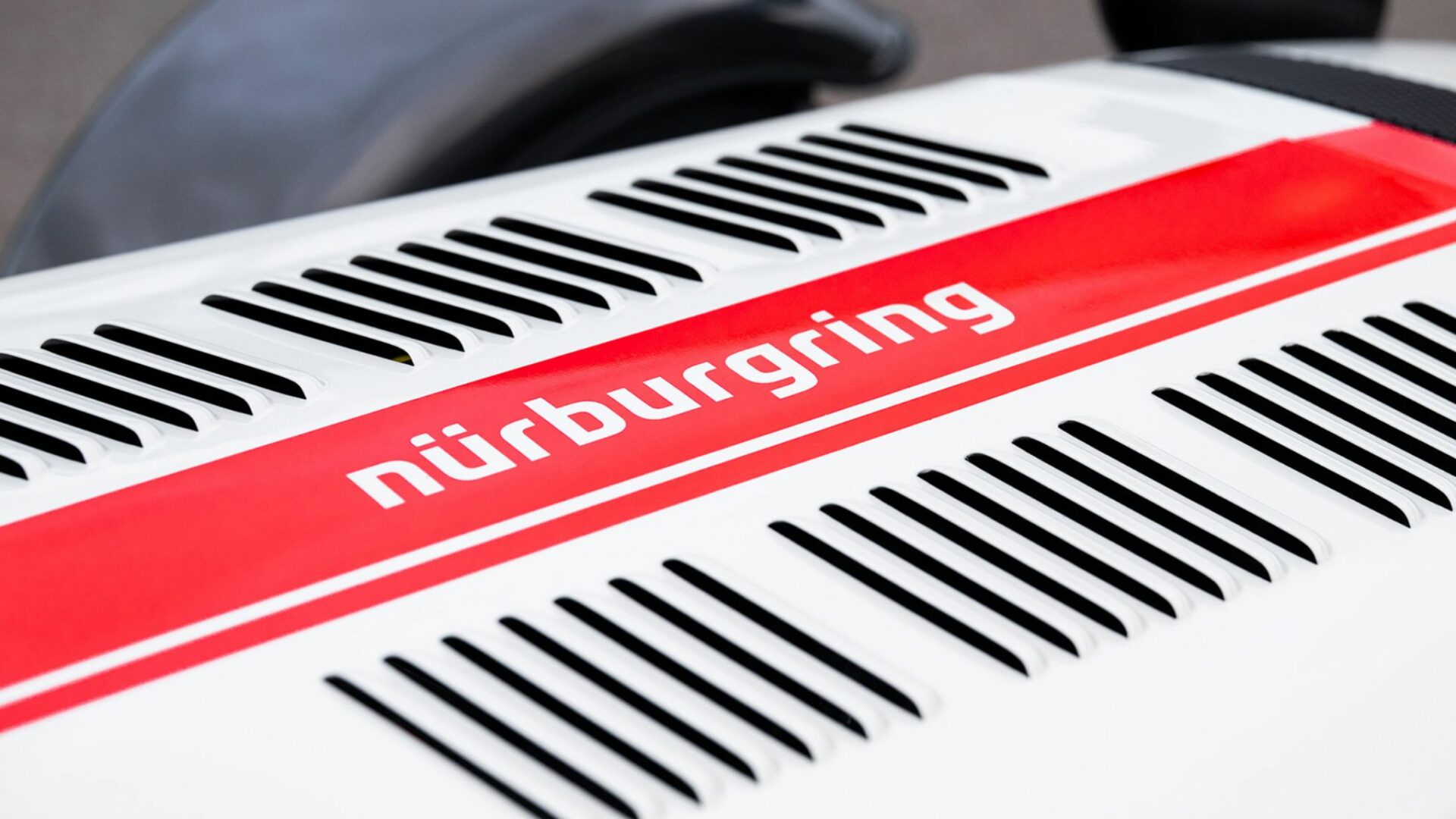 Gros plan sur le capot persienné blanc d'une Caterham Seven Nürburgring Edition avec sa bande rouge et le sticker Nürburgring