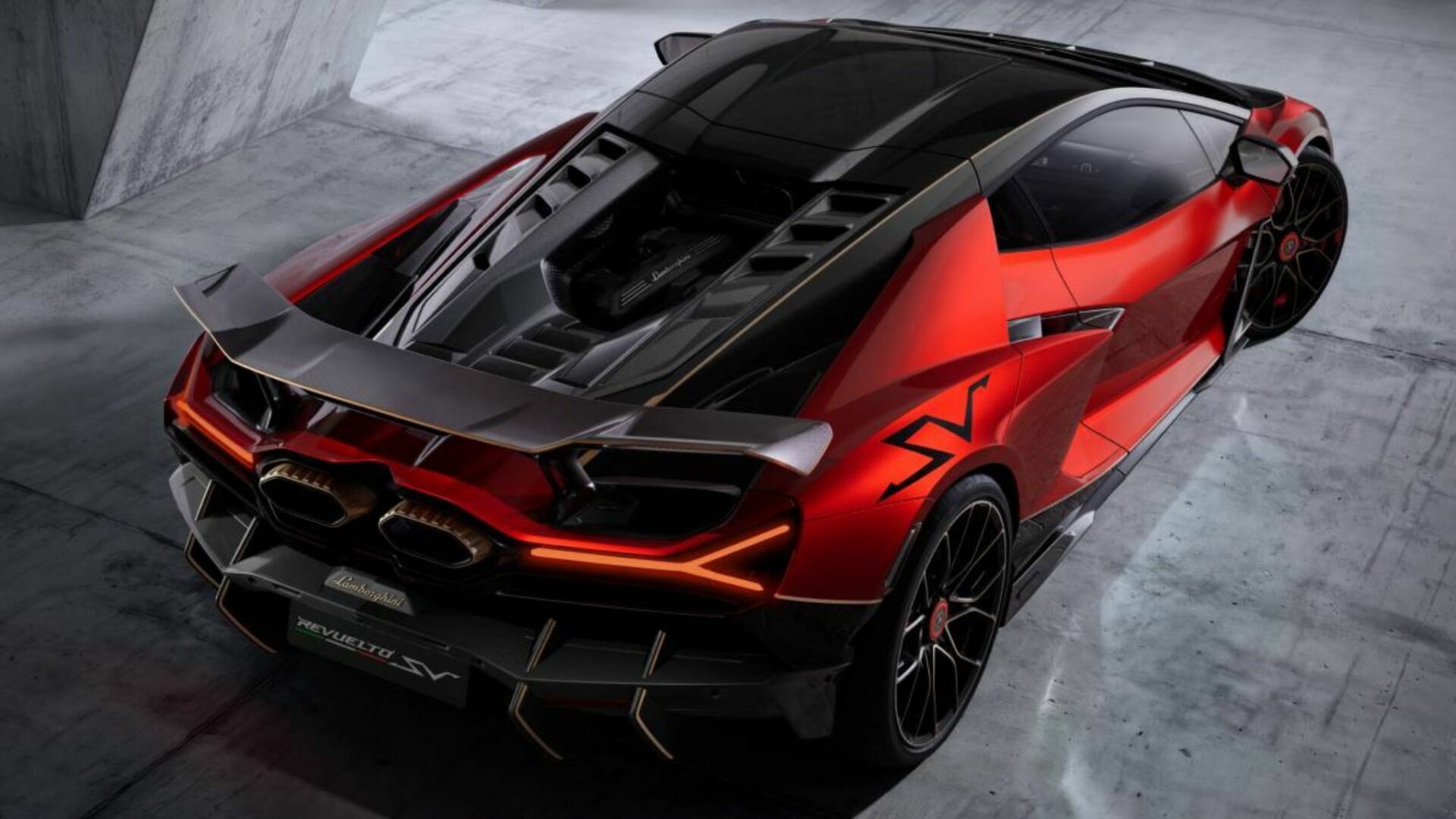 Vue en plongée de trois-quarts arrière de la Lamborghini Revuelto SV rouge révélant le capot moteur V12 en carbone et l'aileron arrière fixe