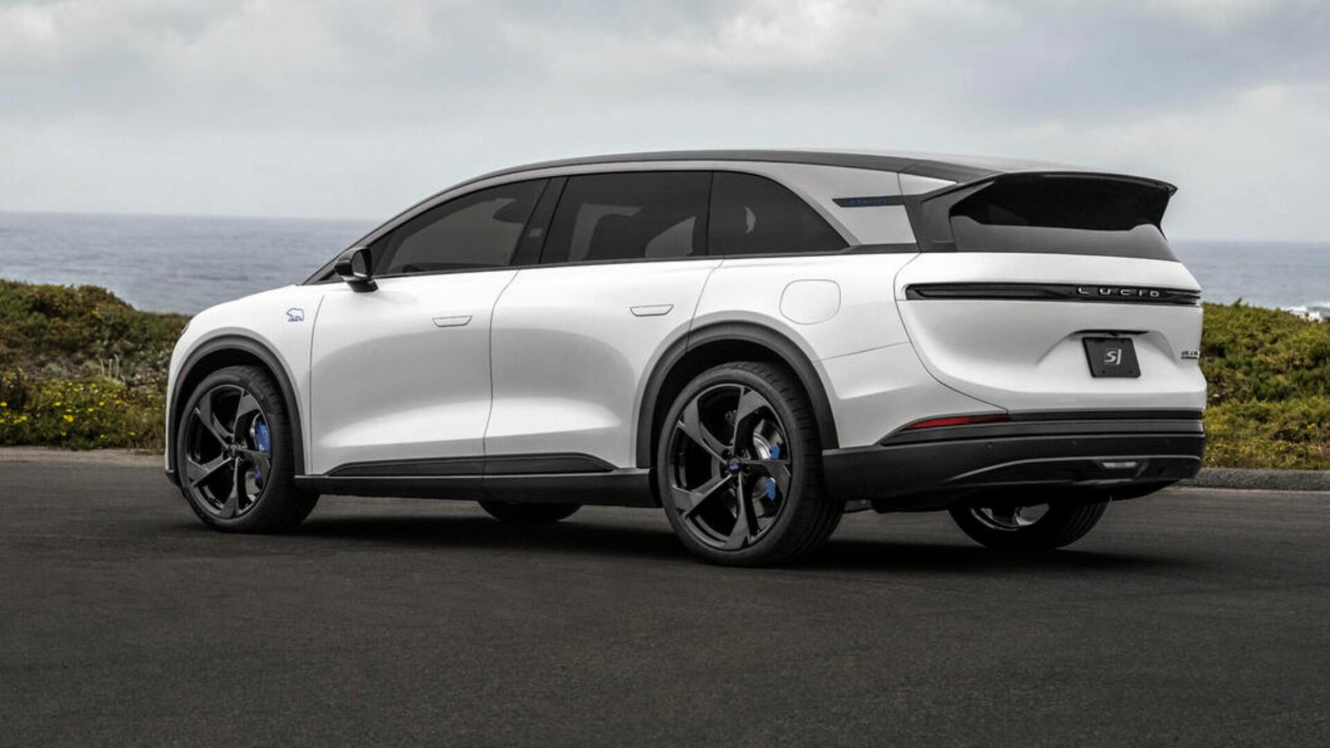 Vue de trois-quarts arrière du Lucid Gravity GT-S blanc montrant sa poupe musclée, son bandeau lumineux LED arrière et le becquet de toit