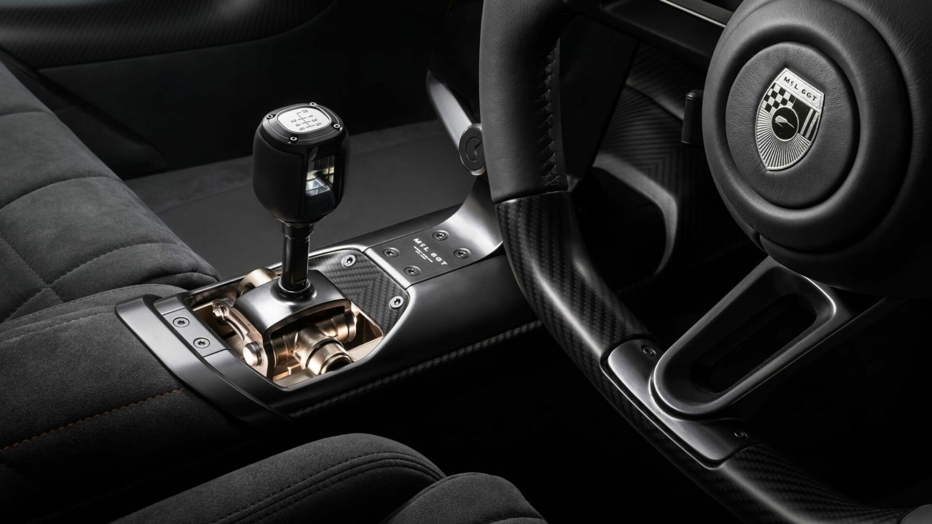 Gros plan sur le levier de vitesse manuel à mécanisme apparent et la grille à 6 rapports dans l'habitacle en Alcantara de la McLaren 6GT