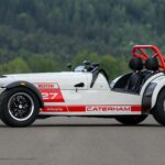 Vue de trois-quarts profil d'une Caterham Seven Nürburgring Edition sur circuit avec livrée blanche et rouge