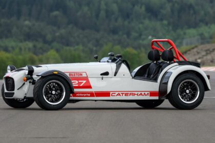 Vue de trois-quarts profil d'une Caterham Seven Nürburgring Edition sur circuit avec livrée blanche et rouge