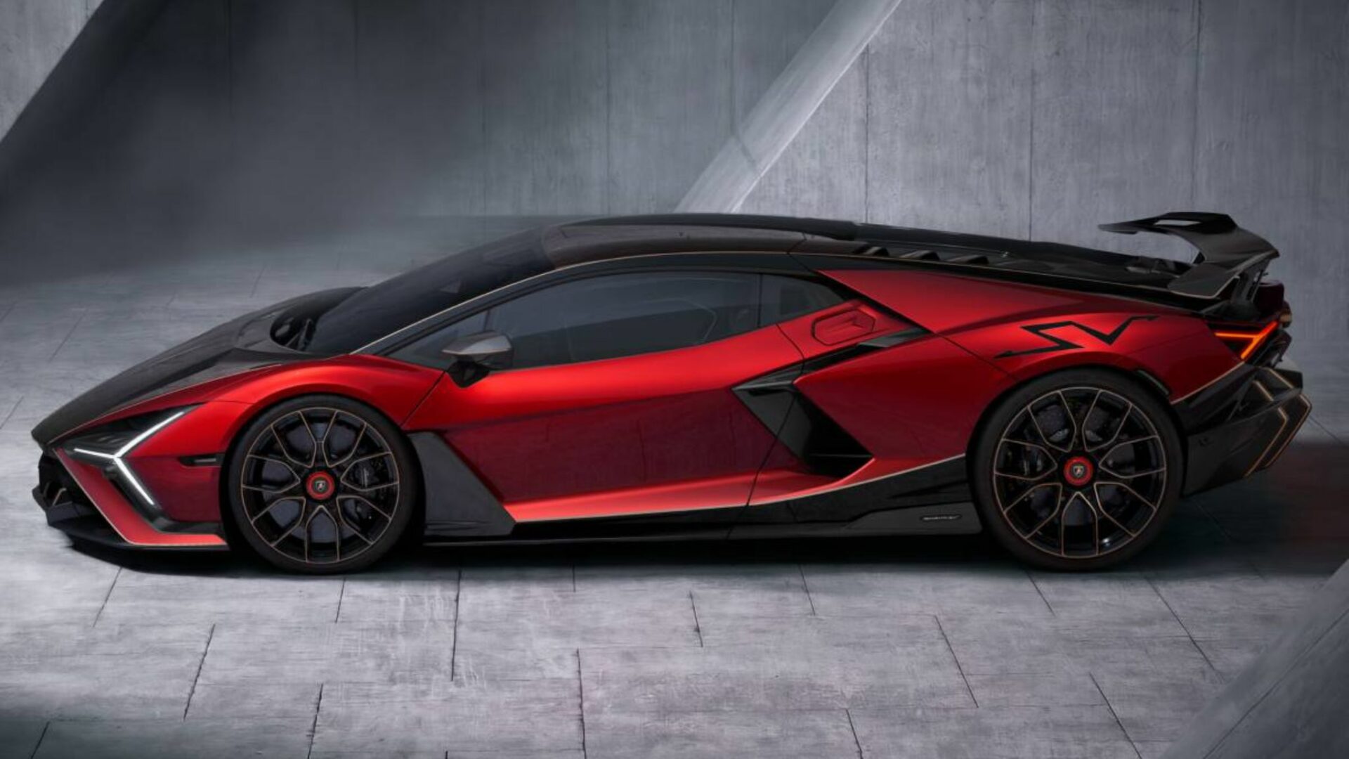 Vue de profil de la Lamborghini Revuelto SV rouge métallisé avec toit et capot en carbone, jantes forgées et logo SV sur l'aile arrière