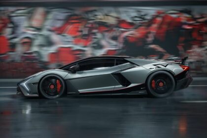 Vue de profil en mouvement de la Lamborghini Revuelto SV gris mat avec étriers de freins rouges et logo SV sur l'aile arrière