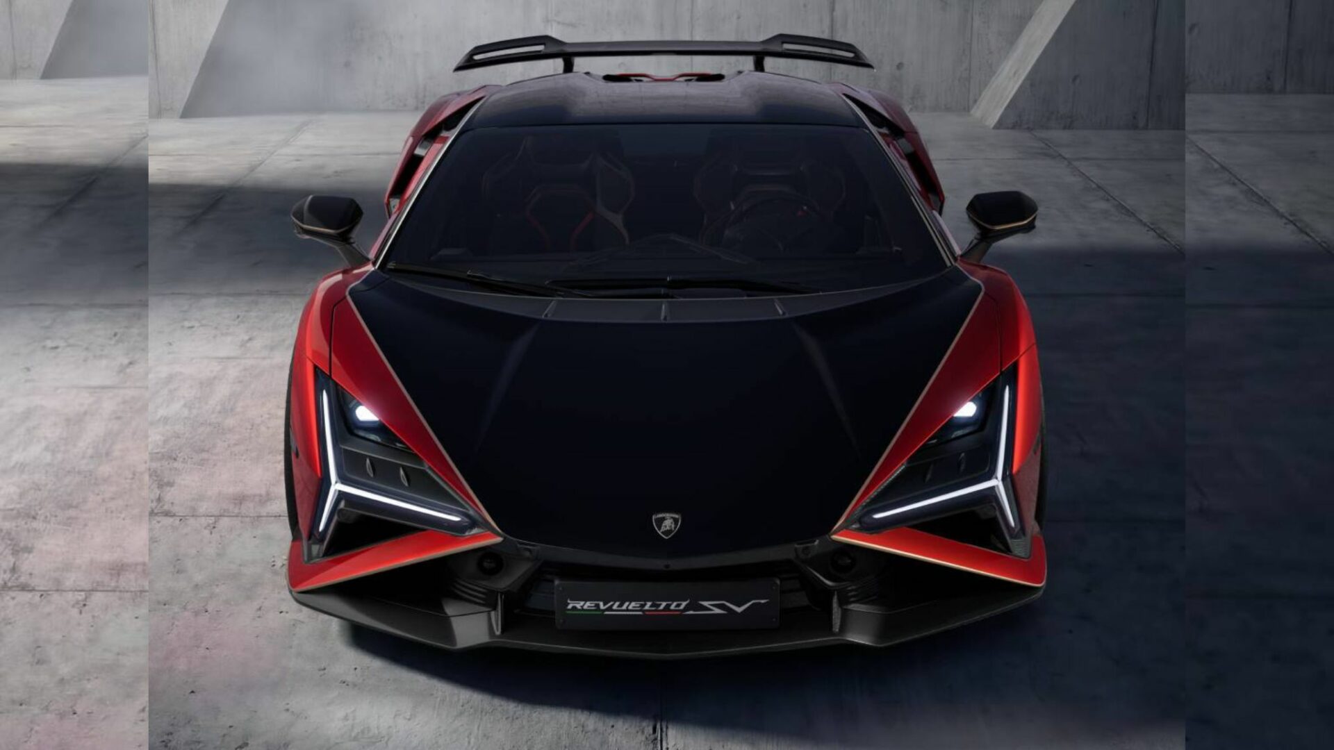 Vue de face de la Lamborghini Revuelto SV rouge et noire montrant la calandre agressive, le capot en carbone et les feux de jour en Y