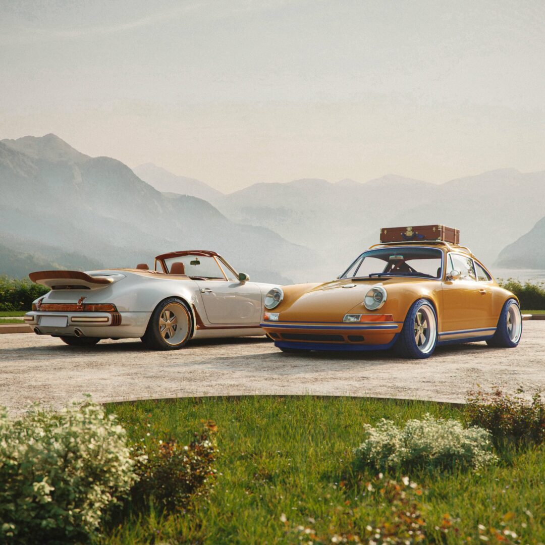 Porsche 911 Louis Vuitton par Singer avec malle de voyage sur le toit stationnée aux côtés du cabriolet blanc devant les montagnes