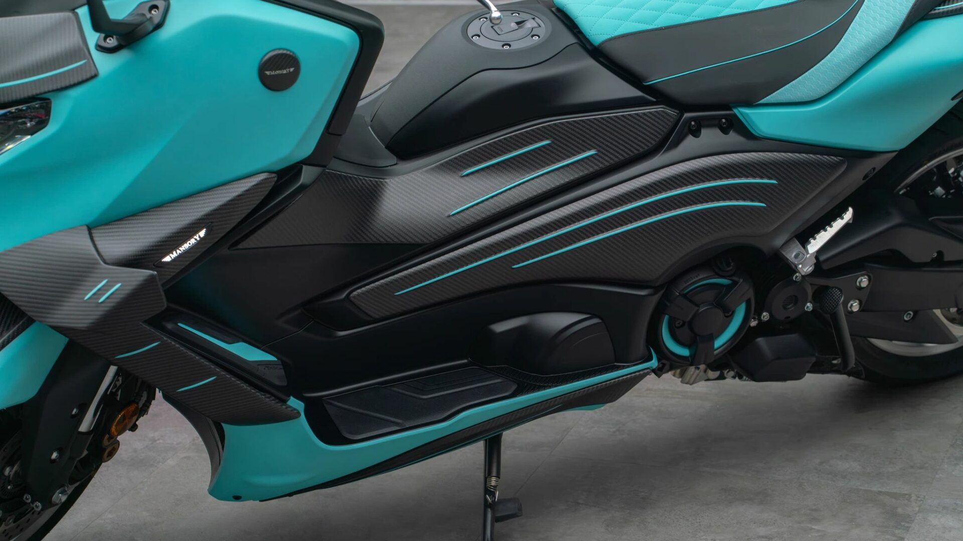 Gros plan sur le flanc latéral en carbone, le marche-pieds et la carrosserie bleu clair du Mansory T-Max