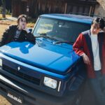 Suzuki Jimny R5 bleu de DAMD avec kit carrosserie façon Renault 5 et deux personnes posant sur le capot