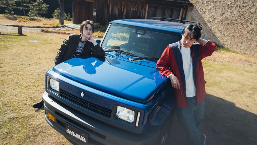 Suzuki Jimny R5 bleu de DAMD avec kit carrosserie façon Renault 5 et deux personnes posant sur le capot