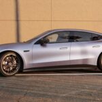 Profil latéral de la Mercedes-AMG GT 4 portes électrique GT 53 couleur gris mat garée devant un mur bétonné