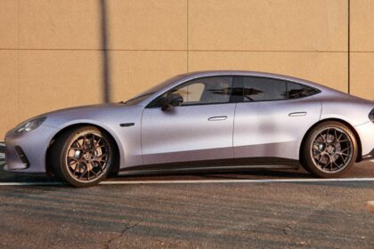 Profil latéral de la Mercedes-AMG GT 4 portes électrique GT 53 couleur gris mat garée devant un mur bétonné