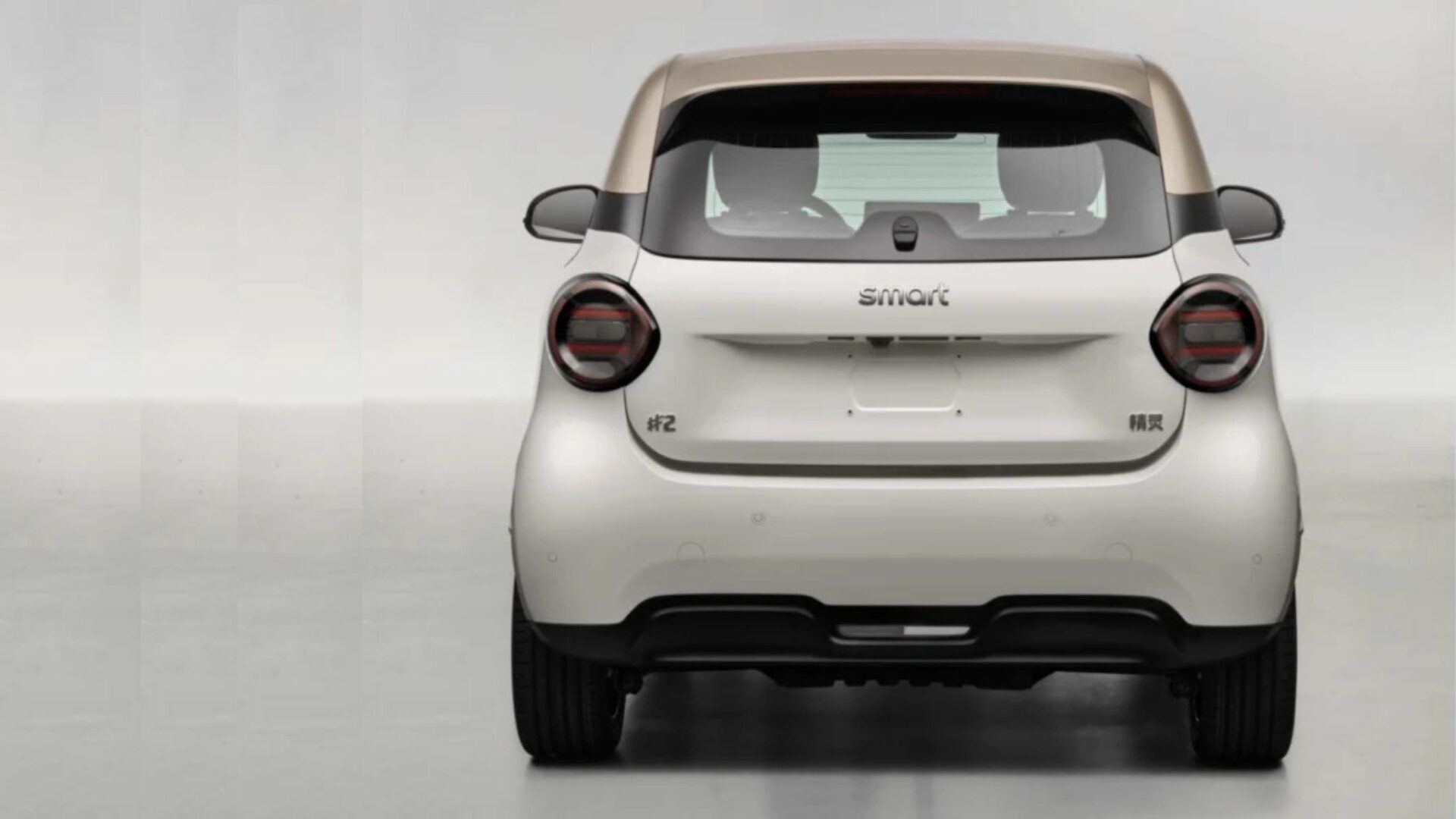Vue plein arrière de la Smart #2 électrique blanche sans camouflage révélant le badge #2 et les feux ronds LED