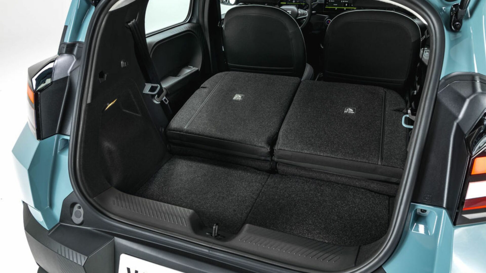 Le coffre de la Nouvelle Dacia Spring avec la banquette arrière rabattue offrant jusqu'à 1 283 litres de chargement.