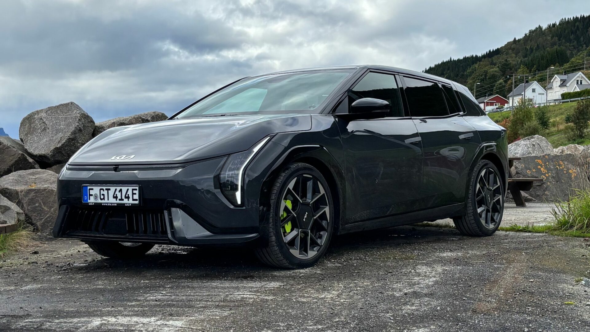 Gros plan de trois quarts avant sur la nouvelle Kia EV4 GT grise stationnée sur un site côtier rocailleux lors des essais en Norvège.
