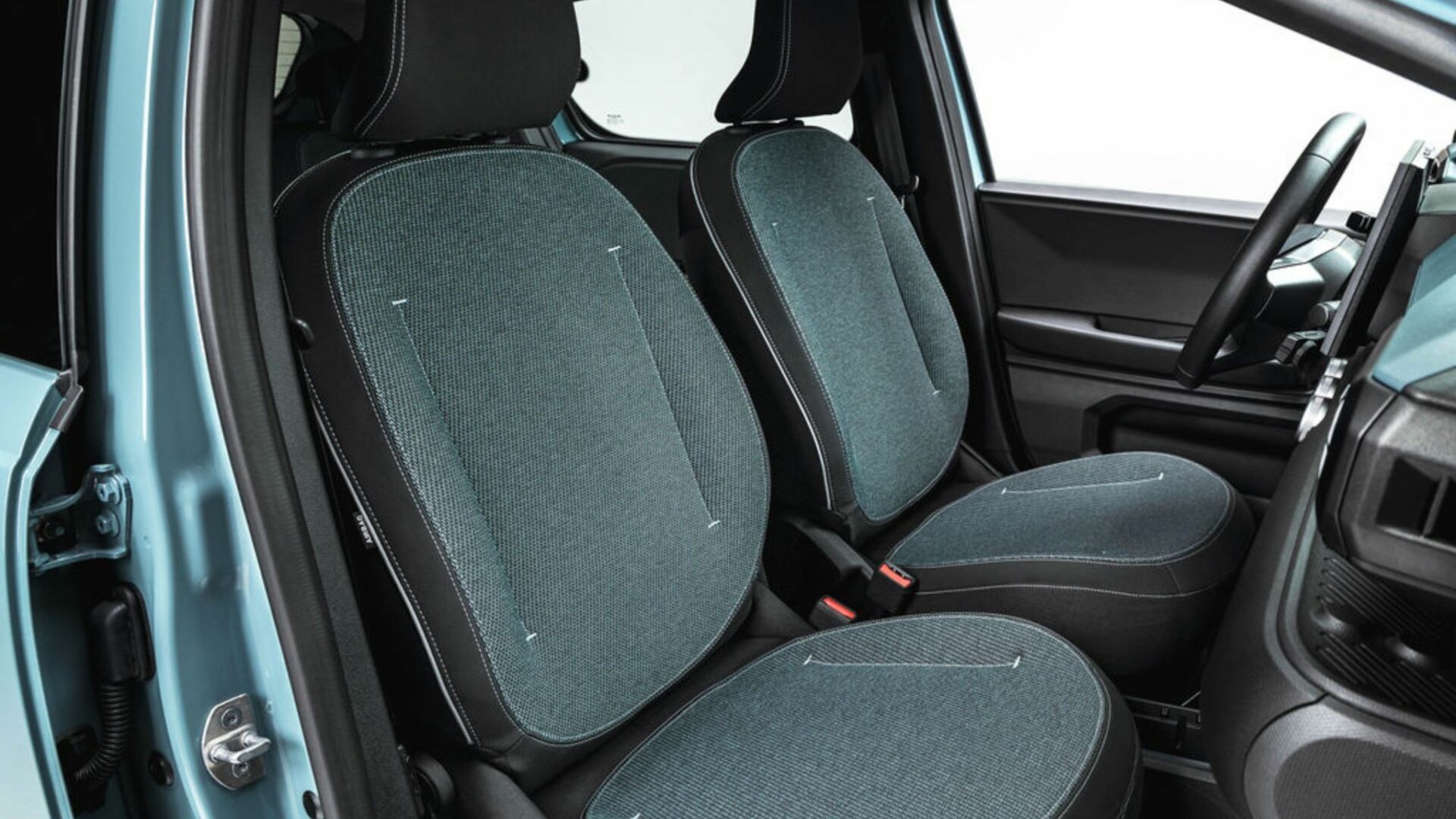 Les sièges avant de la Nouvelle Dacia Spring avec leur sellerie en tissu aux accents bleutés rappelant la teinte extérieure Agave.