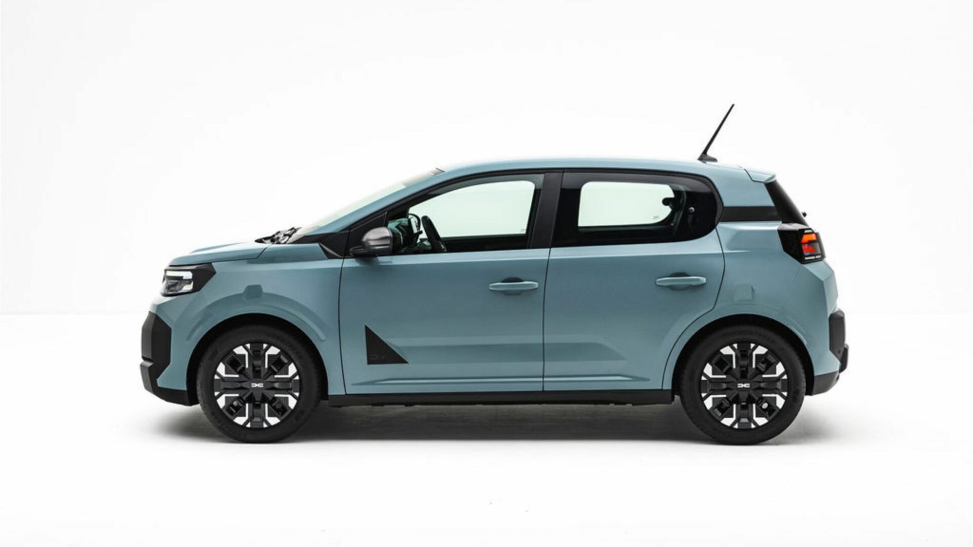 Vue de profil latéral de la Nouvelle Dacia Spring dans sa teinte Agave, illustrant ses nouvelles proportions et sa garde au sol