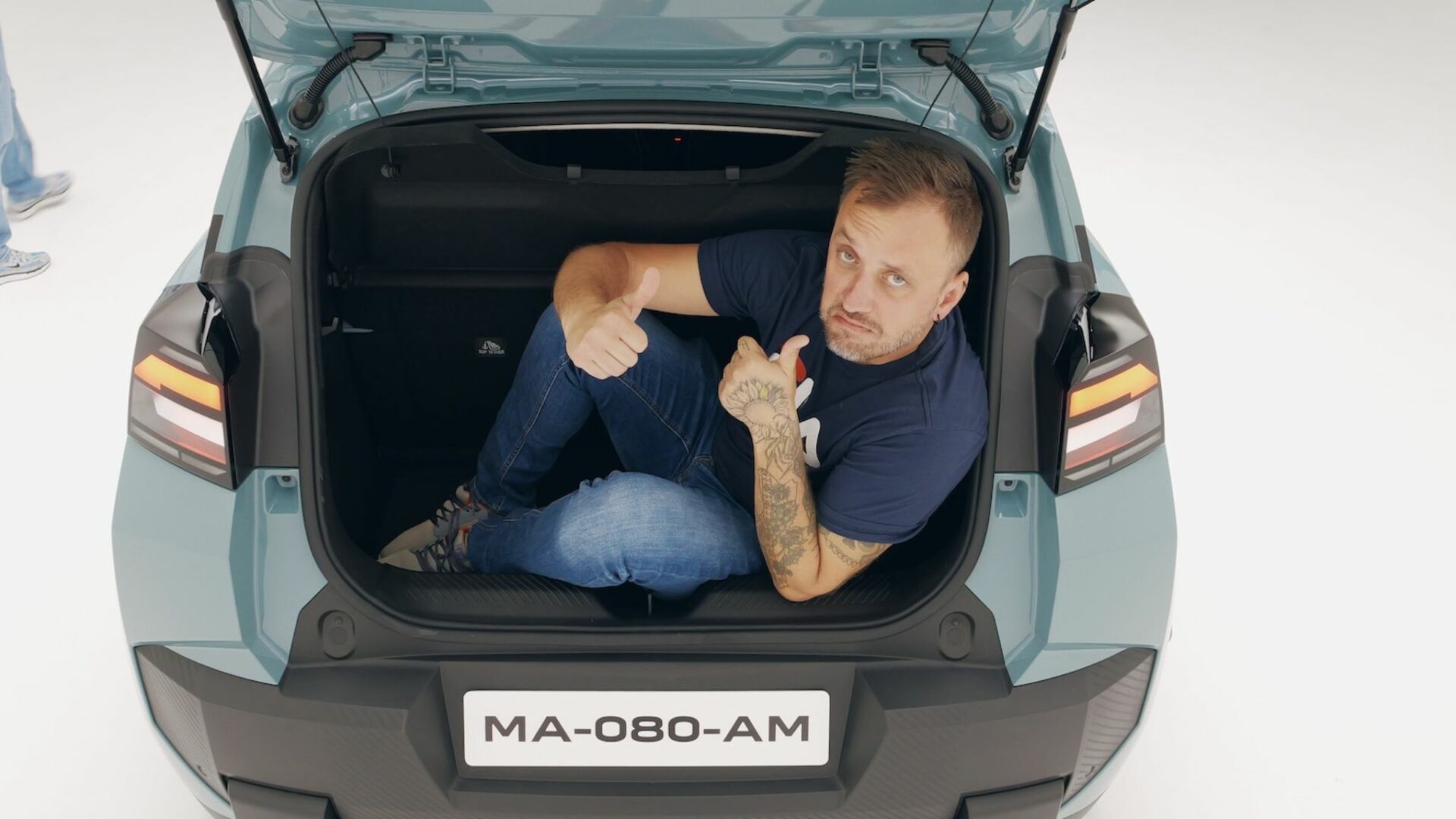 Le célèbre youtubeur automobile Victor Diakov assis dans le coffre de la Nouvelle Dacia Spring pour tester son volume record de 337 litres.