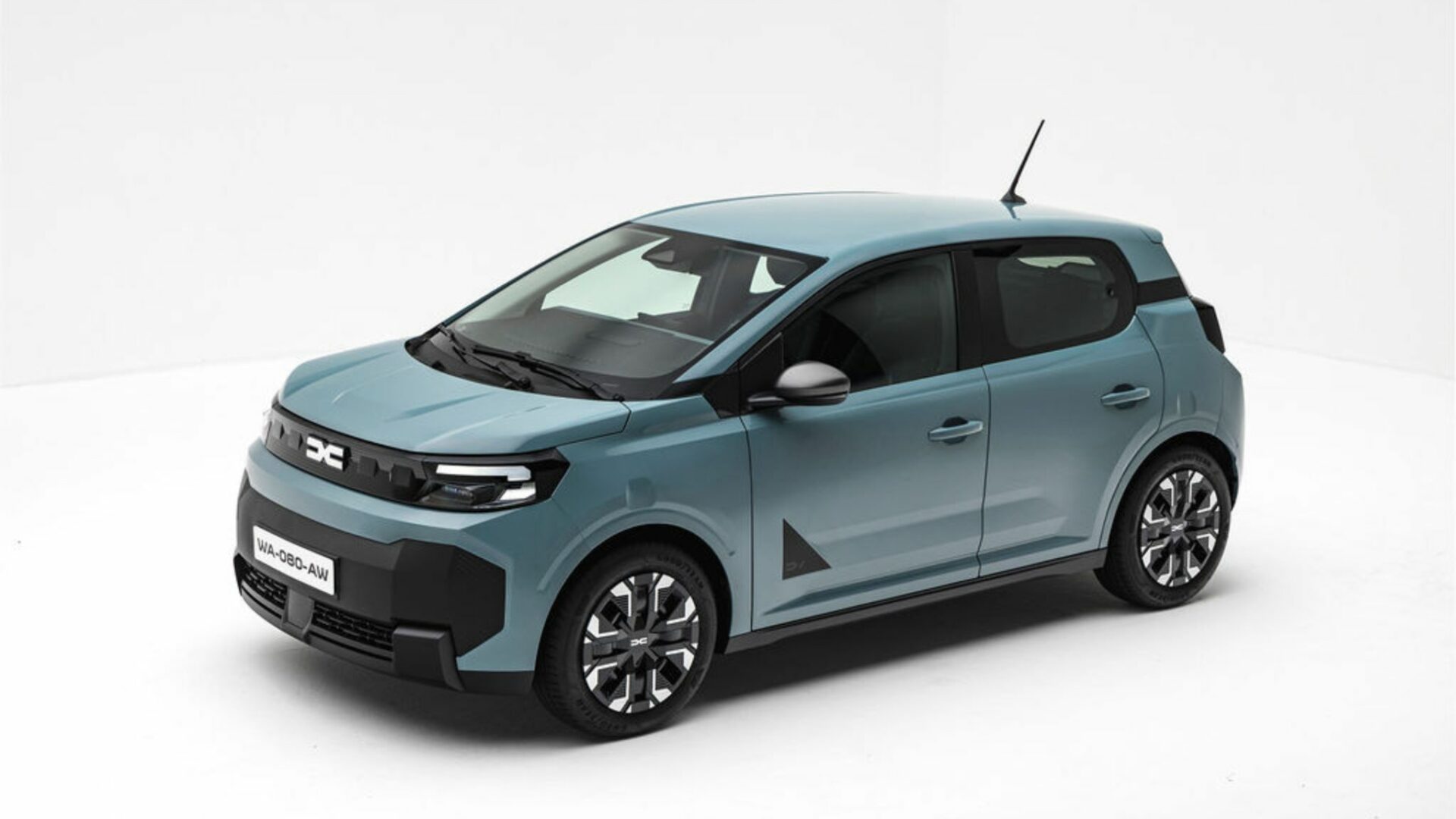 Vue aérienne de trois quarts avant de la Nouvelle Dacia Spring en studio, exposant son design extérieur moderne et sa teinte Agave