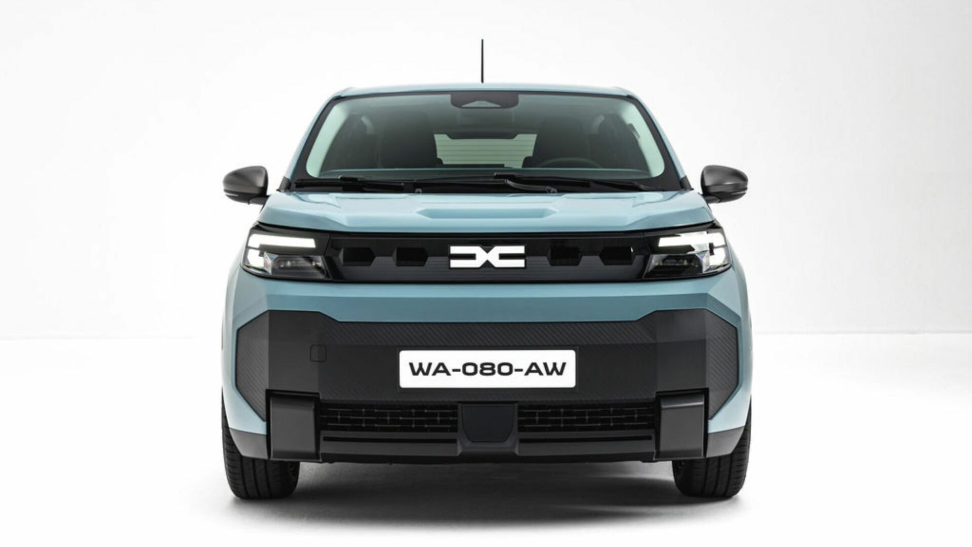 Vue de face pure de la Nouvelle Dacia Spring en studio, mettant en valeur son bouclier texturé et son design affirmé.