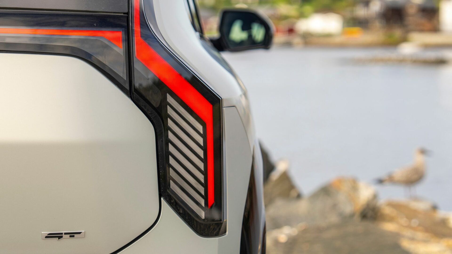 Gros plan sur la signature lumineuse arrière à LED et le monogramme GT de la nouvelle Kia EV3 GT.